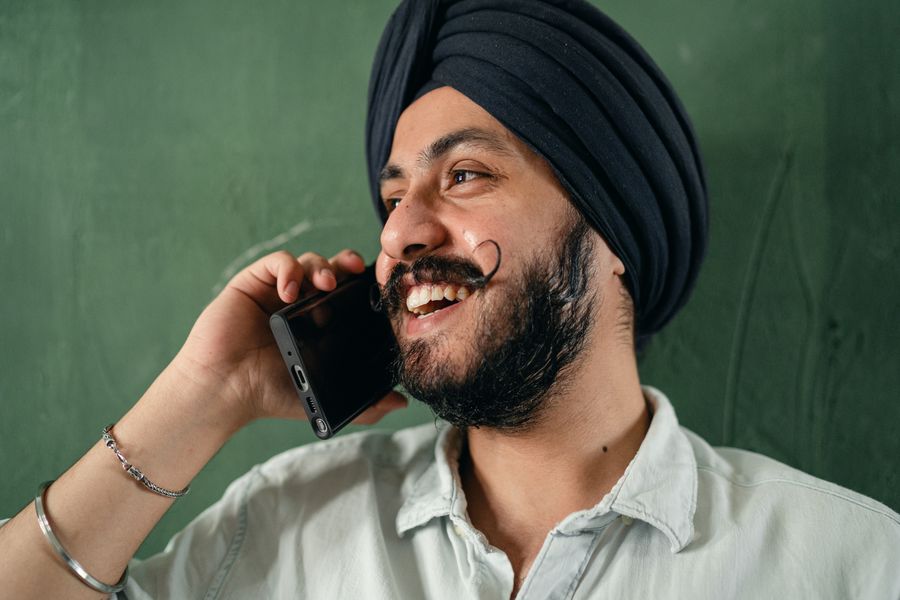 A cheerful young man talking on his phone