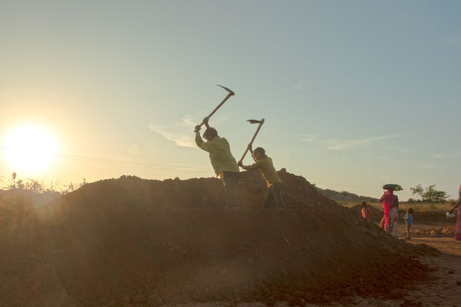 Silhouettes of daily-wage labourers working at dawn